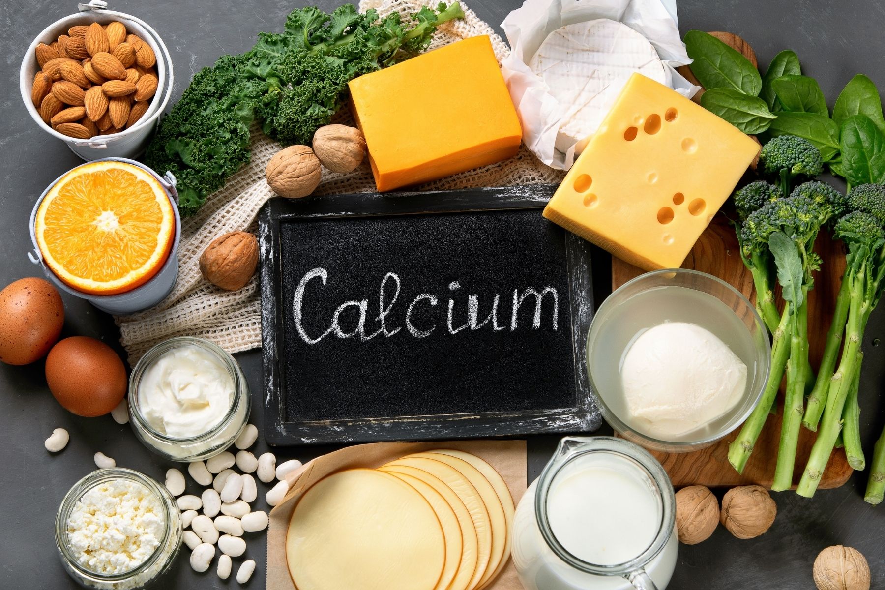 Calcium rich foods to add to your diet on grey background.