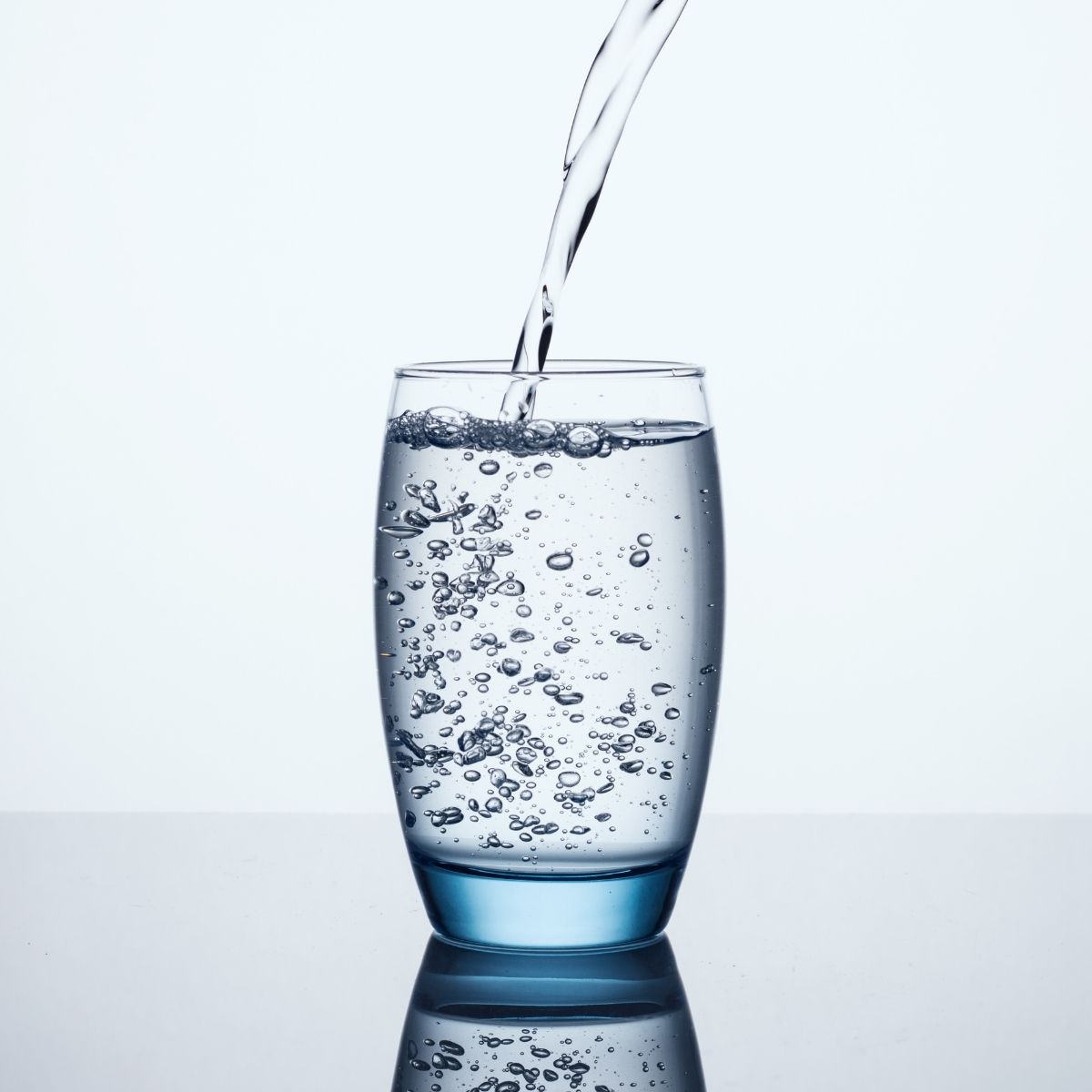 Whay water after massage is important for improved results illustrated by a glass of fresh water being poured.